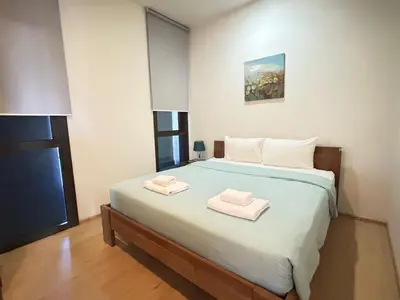 a bedroom with a bed with two towels on it at 2 Bedroom Beachfront Apartment With Sea Views in Mai Khao Beach