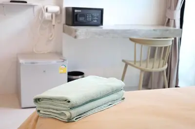 a stack of towels sitting on top of a bed at Y House Patong in Patong Beach