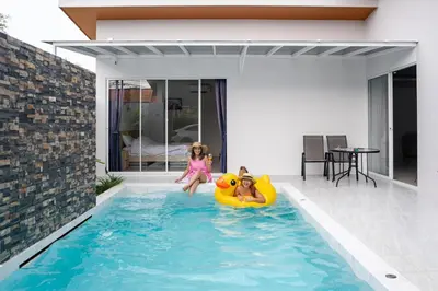 two children playing in a swimming pool in a house at Sasi Pool Villa Phuket in Rawai Beach