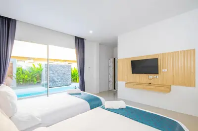 a hotel room with two beds and a television at Sasi Pool Villa Phuket in Rawai Beach