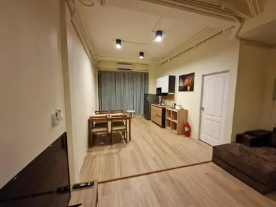 a living room with a table and a kitchen at Bonanza Patong Beach1 100m to Beach Star Room in Patong Beach