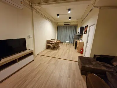 a living room with a couch and a television and a table at Bonanza Patong Beach1 100m to Beach Star Room in Patong Beach