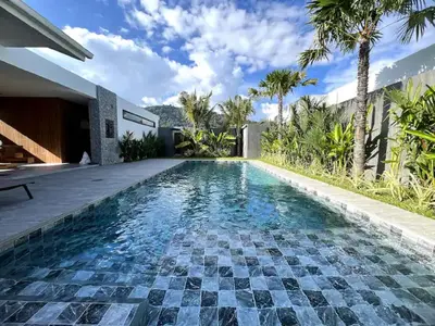 a swimming pool with a tile floor and a house at Villa Christal - Modern 3 bedrooms with pool in Ban Saiyuan (1)