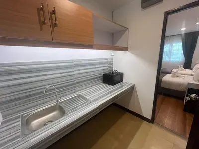 a kitchen counter with a sink and a bed at MYP Cherngtalay in Phuket Town