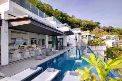 a resort with a pool with chairs and a bar at Villa Amonteera in Surin Beach