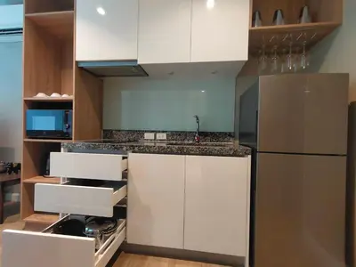 a kitchen with white cabinets and a stainless steel refrigerator at 1 Bedroom Pool view at Diamond Condo, Bangtao in Bang Tao Beach