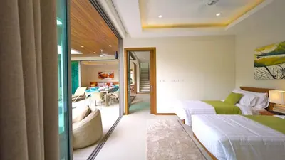 a bedroom with two beds and a living room at 4 Bedrooms Private Pool Villa near Rawai Beach in Rawai Beach