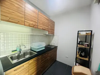 a small kitchen with a sink and wooden cabinets at Arin Townhome @Bangtao in Ban Thalat Choeng Thale