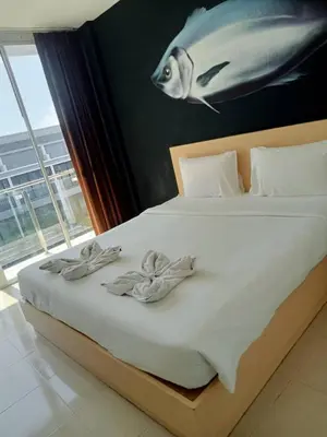 a bedroom with a bed with a fish painting on the wall at XX GO INN Aonang Beach โกอินน์ หาดอ่าวนาง in Ban Khlong Haeng