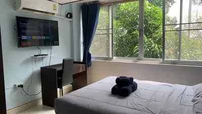 a teddy bear sitting on a bed in a bedroom at Apartment in Rawai in Rawai Beach