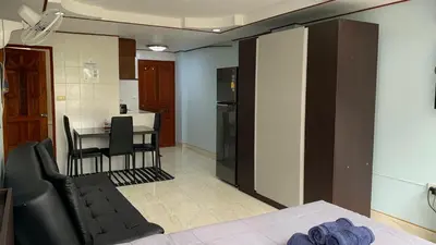 a room with a kitchen and a table with a chair at Apartment in Rawai in Rawai Beach