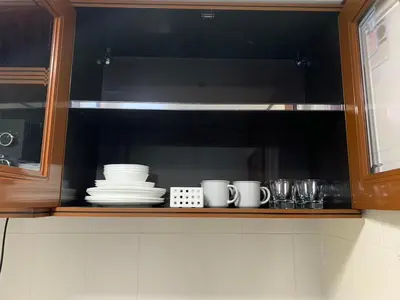 a kitchen cabinet with cups and plates on a shelf at Apartment in Rawai in Rawai Beach