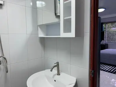 a white bathroom with a sink and a mirror at Apartment in Rawai in Rawai Beach
