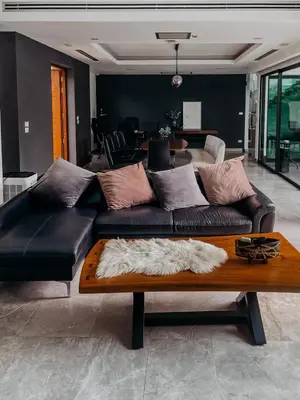 a living room with a leather couch and a table at Tropical Haven 4 Bedroom Pool Villa in Bang Tao Beach