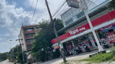 a street with a building and motorcycles parked on the street at Rawai beach condominium Phuket in Nai Harn Beach