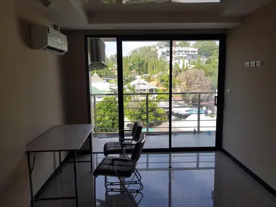 a room with a table and two chairs and a balcony at Rawai beach condominium Phuket in Nai Harn Beach