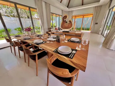 a dining room with a large wooden table and chairs at New luxury villa with maid Anchan Tropicana in Bang Tao Beach
