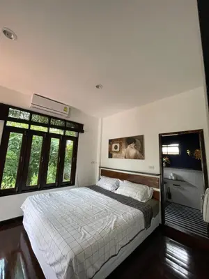 a bedroom with a bed and two windows at Aisawan Resort villa in Surin Beach