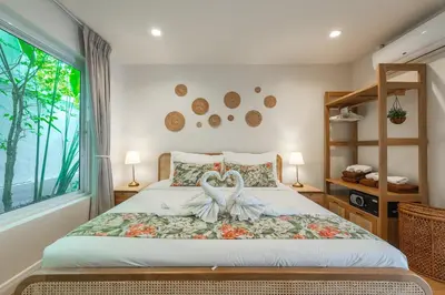 a bedroom with a bed with two swans on it at Rosemary Villa 4 bedrooms with Pool near BangTao Beach in Bang Tao Beach