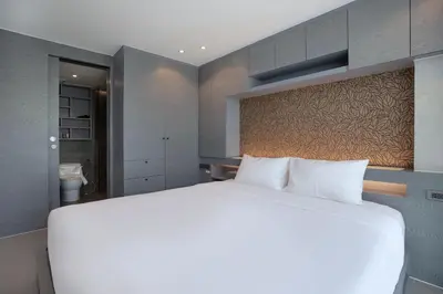 a bedroom with a large white bed in a room at Tropics Kamala Hill View Suite CTG D707, near Beach and Fantasea in Kamala Beach