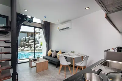 a living room with a table and a couch at Pool Access Utopia Loft, just 10 min from Nai Harn Beach, UTL A116 in Rawai Beach