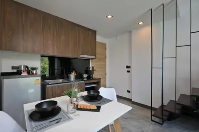 a kitchen with a white table with bowls on it at Pool Access Utopia Loft, just 10 min from Nai Harn Beach, UTL A116 in Rawai Beach