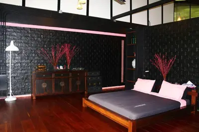 a bedroom with a bed and a black brick wall at 05 - Exquisite Paradise Retreat in Nai Thon Beach