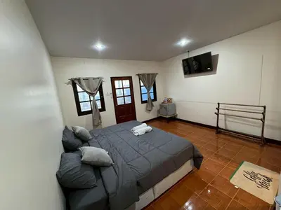 a bedroom with a bed and a couch in it at Baan Ni Khun in Ban Lo Ti Pa (1)