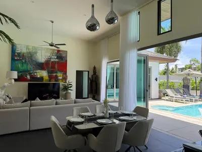 a living room with a table and a couch at Pool Villa - 3 Bedroom- Walking to Bangtao Beach, Restaurants and Supermarkets in Bang Tao Beach
