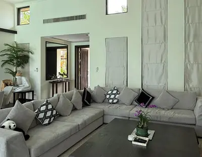 a living room with a couch with pillows on it at Pool Villa - 3 Bedroom- Walking to Bangtao Beach, Restaurants and Supermarkets in Bang Tao Beach