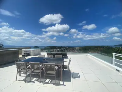 a patio with a table and chairs on a roof at The View Luxury Condominium Karon in Kata Beach