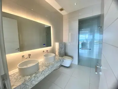 a bathroom with two sinks and a mirror and a toilet at The View Luxury Condominium Karon in Kata Beach