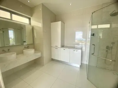 a bathroom with two sinks and a glass shower at The View Luxury Condominium Karon in Kata Beach