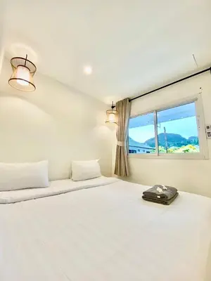 a white bedroom with a bed and a window at BB Hidden House in Phi Phi Don