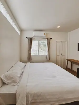 a bedroom with a large white bed and a window at Casa Maya House in Phi Phi Don