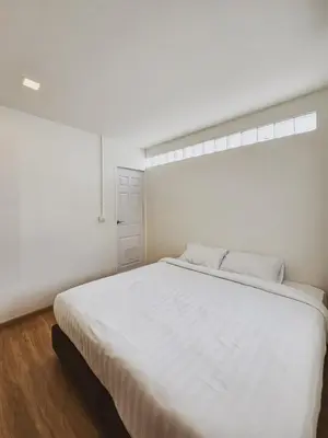 a bedroom with a large white bed with a window at Casa Maya House in Phi Phi Don