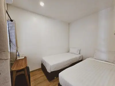 a small room with two beds and a table at Casa Maya House in Phi Phi Don