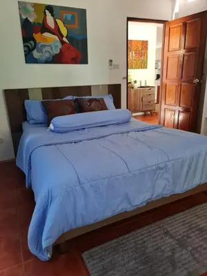 a bedroom with a large bed with a blue comforter at Grand Luxe Kamala in Kamala Beach