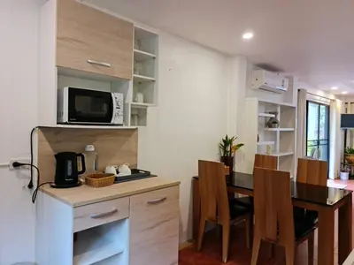 a kitchen and dining room with a table and a microwave at Grand Luxe Kamala in Kamala Beach