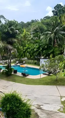 a swimming pool in a resort with palm trees at Grand Luxe Kamala in Kamala Beach
