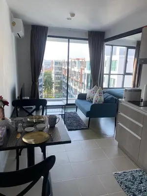 a living room with a couch and a table at Centrio Condominiums Top Floor with Pool and Garden view in Ban Na Khua