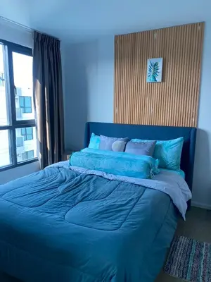 a blue bed in a room with a window at Centrio Condominiums Top Floor with Pool and Garden view in Ban Na Khua