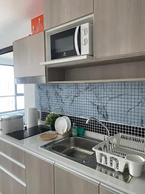 a kitchen with a sink and a microwave at Centrio Condominiums Top Floor with Pool and Garden view in Ban Na Khua