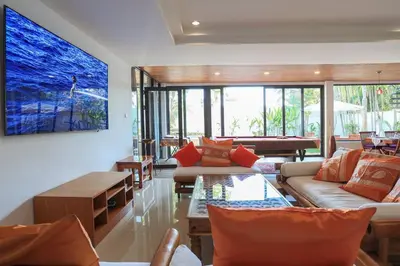 a living room with couches and a large painting on the wall at Coconut Palms huge swimming pool and pool table V136 in Rawai Beach