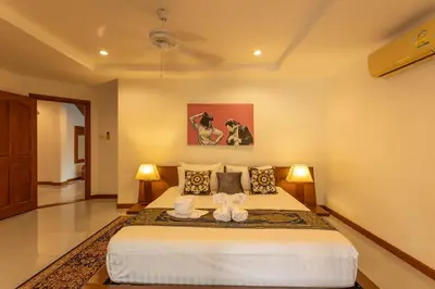 a bedroom with a large bed with two stuffed animals on it at Coconut Palms huge swimming pool and pool table V136 in Rawai Beach