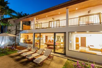 a group of chairs in front of a house at Coconut Palms huge swimming pool and pool table V136 in Rawai Beach