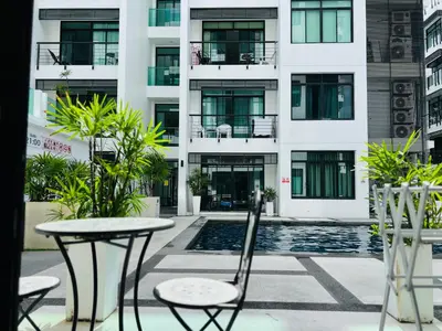 a table and chairs in front of a building at Kamala Regent by RESAVA in Kamala Beach