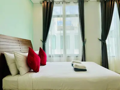 a bedroom with a bed with red pillows and a phone at Kamala Regent by RESAVA in Kamala Beach