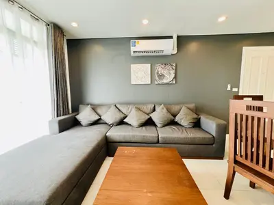 a gray couch in a living room with a window at Kamala Regent by RESAVA in Kamala Beach