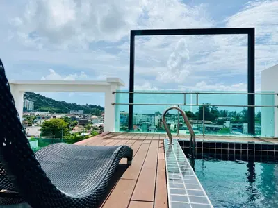 a swimming pool with a chair on a balcony at Kamala Regent by RESAVA in Kamala Beach